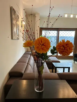 a vase with orange flowers on a table in a living room at Carpegna Luxury apt with terrace in Rome