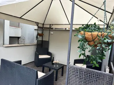 a patio with a table and chairs and an umbrella at Carpegna Luxury apt with terrace in Rome