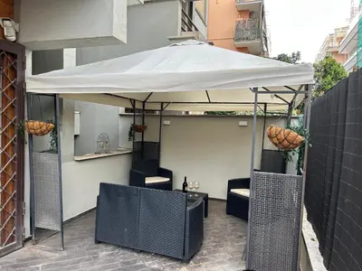 a white umbrella over a table and chairs on a patio at Carpegna Luxury apt with terrace in Rome