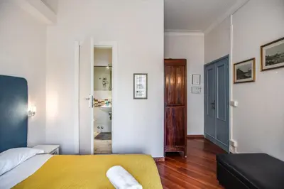 a bedroom with a yellow bed and a hallway at Circus Maximus B&B in Rome