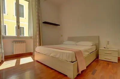 a bedroom with a bed and a large window at Colosseo Apt Mecenate 77 - Home and More in Rome