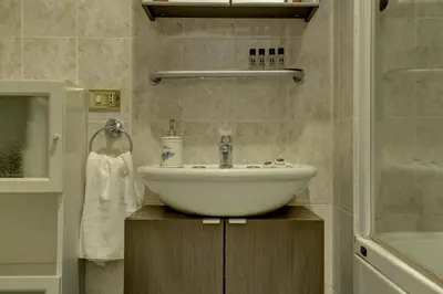 a bathroom with a white sink and a shower at Colosseo Apt Mecenate 77 - Home and More in Rome