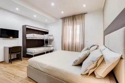 a bedroom with a bed and a desk and a television at San Pietro Vatican Apartments in Rome