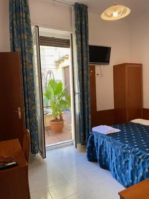 a room with a bed and a sliding glass door at Guest House Pitagora in Rome