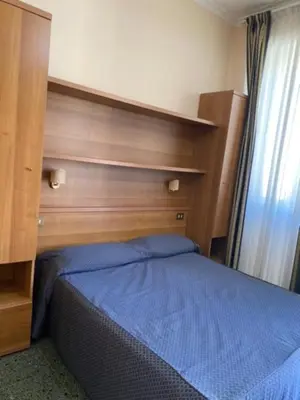 a bedroom with a blue bed with a wooden headboard at Guest House Pitagora in Rome