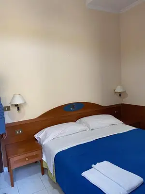 a bedroom with a blue and white bed with two towels at Guest House Pitagora in Rome
