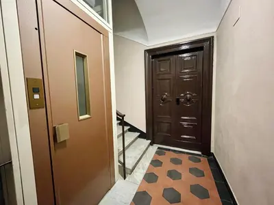 a hallway with a brown door and a tile floor at h135 in Rome