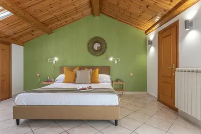 a bedroom with a bed and green walls at BBHOME Domus aquae inside of appia antica park in Rome