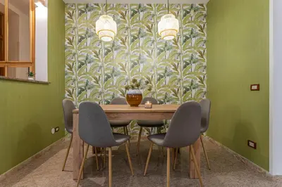 a dining room with a table with chairs and a wallpaper at BBHOME Domus aquae inside of appia antica park in Rome
