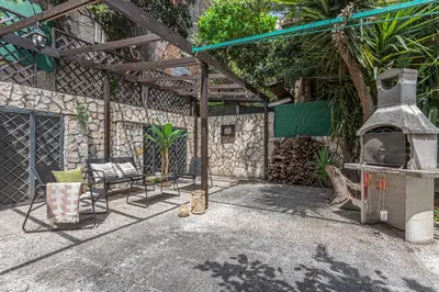 a outdoor patio with a grill and chairs and a table at BBHOME Domus aquae inside of appia antica park in Rome