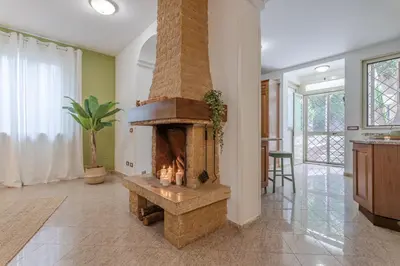 a living room with a stone fireplace in a house at BBHOME Domus aquae inside of appia antica park in Rome