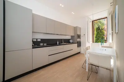 a kitchen with white cabinets and a table and a window at Appia96 Apartments in Rome