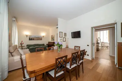 a dining room and living room with a table and chairs at Appia96 Apartments in Rome
