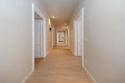 an empty hallway with white walls and wood floors at Appia96 Apartments in Rome