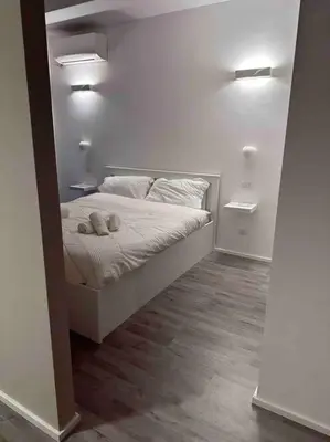 a bedroom with a bed with a stuffed animal on it at Cozy design studio apartment in Porta Maggiore. in Rome