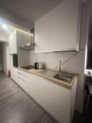 a kitchen with white cabinets and a sink at Cozy design studio apartment in Porta Maggiore. in Rome