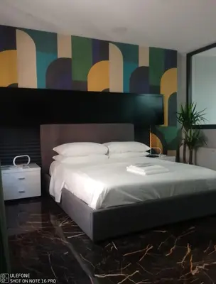 a bedroom with a large white bed and a colorful wall at Delizioso appartamento in Rome