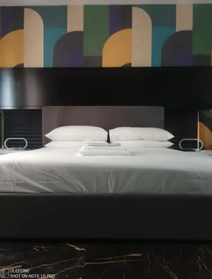 a large bed with white sheets and pillows at Delizioso appartamento in Rome