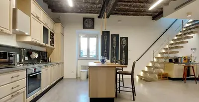 a large kitchen with a counter and a stairway at Loft 133 - Central and Luxury Loft in Rome in Rome