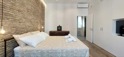 a bedroom with a bed and a brick wall at Loft 133 - Central and Luxury Loft in Rome in Rome