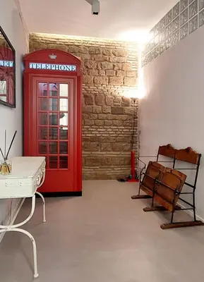 a red phone booth in a room with a desk and chairs at Loft 133 - Central and Luxury Loft in Rome in Rome