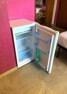a small white refrigerator with its door open at Villa Elena in Rome