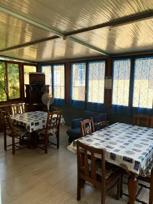 a dining room with a table and chairs and windows at Villa Elena in Rome