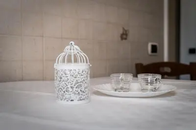 a bird cage sitting on a table with two glasses at Appartamento San Giovanni Liliana in Rome