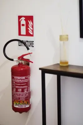 a fire extinguisher hanging on a wall next to a table at Appartamento San Giovanni Liliana in Rome