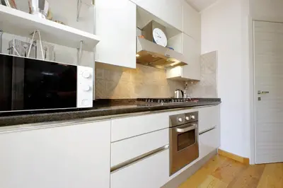 a kitchen with white cabinets and a microwave at 4BNB - Trionfale Apartment in Rome