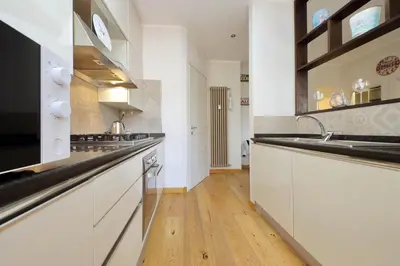 a large kitchen with white cabinets and a sink at 4BNB - Trionfale Apartment in Rome