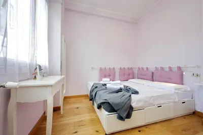 a white bedroom with a bed and a desk at 4BNB - Trionfale Apartment in Rome