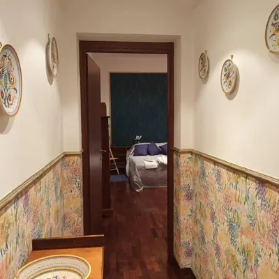 a hallway with a room with a bed and plates on the wall at La Casa di Filippo in Rome
