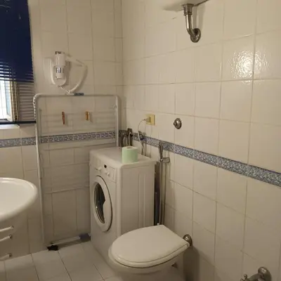 a white bathroom with a toilet and a sink at La Casa di Filippo in Rome