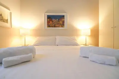 a bedroom with two white beds with two lamps at A 10 passi dal Vaticano in Rome