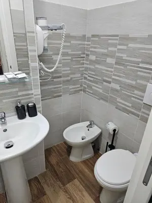 a bathroom with a white sink and a toilet at Trastevere Guestrooms in Rome