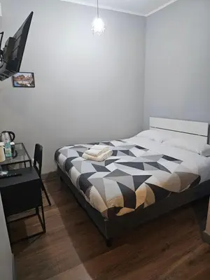 a bedroom with a black and white bed and a desk at Trastevere Guestrooms in Rome