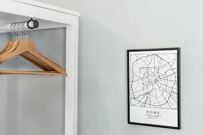 a picture of a home in a hallway with a hanger and a poster at Trastevere Guestrooms in Rome