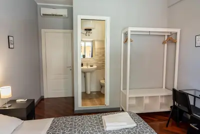 a bedroom with a mirror and a bathroom with a sink at Trastevere Guestrooms in Rome