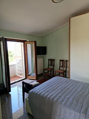 a bedroom with a bed and chairs and a balcony at Castelbarco House F in Rome