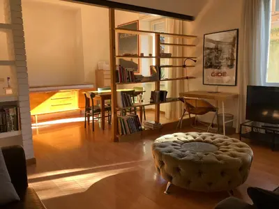 a living room with a ottoman in the middle of a room at Monti Parioli House in Rome