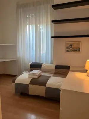 a bedroom with a bed and a window with white curtains at Monti Parioli House in Rome