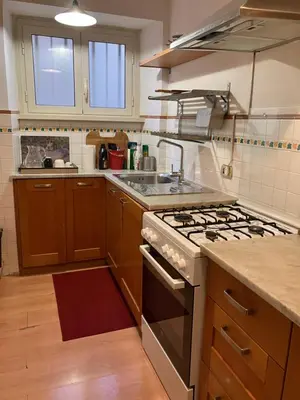 a kitchen with wooden cabinets and a stove top oven at Monti Parioli House in Rome
