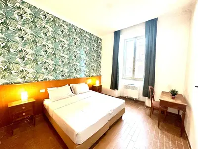 a bedroom with a bed and a floral wall at Trevi Romantic Alcova in Rome