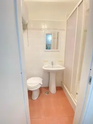 a white bathroom with a toilet and a sink at Hotel Resi in Rome