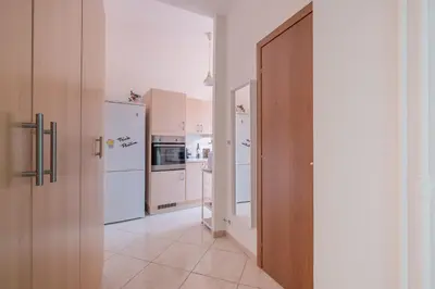 a kitchen with white appliances and a wooden door at San Giovanni Dream House in Rome
