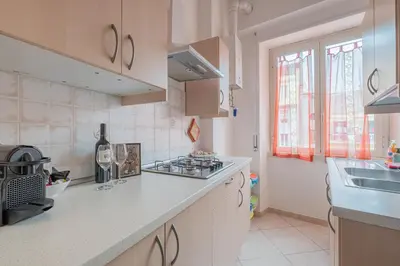 a kitchen with white cabinets and a counter top at San Giovanni Dream House in Rome