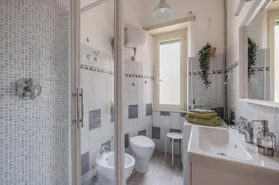 a bathroom with a sink and a toilet and a mirror at San Giovanni Dream House in Rome