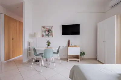 a white room with a table and chairs at San Giovanni Dream House in Rome