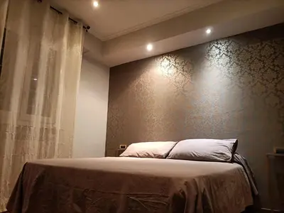 a bedroom with a bed and a wall withcriptions at DOMUS VACANZE ROMANE in Rome